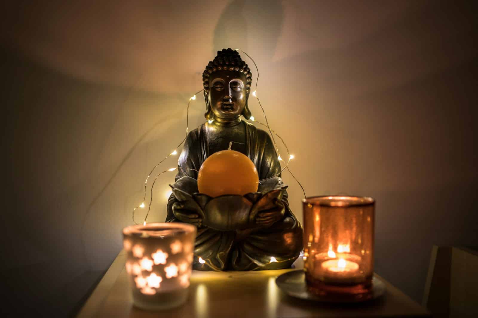 gold buddha figurine beside lighted candles